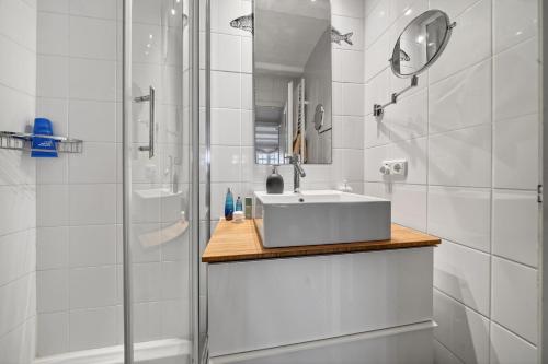 a white bathroom with a sink and a shower at Stutenhof-EG-Wohnung-3 in Keitum