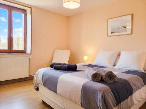 a bedroom with a large bed with towels on it at Maison Céline - Jardin clos et Parking Privé Gratuit in Crevant-Laveine