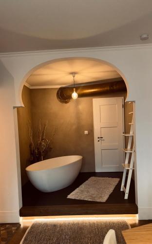 a bathroom with a large tub and a ladder at Atemberaubende Ferienwohnung direkt am See in Brienz