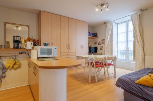 una cucina con un tavolo con un computer sopra di Chez Maïté a Vals-les-Bains