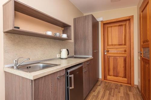 a kitchen with a sink and a wooden door at Palangos Vila in Palanga