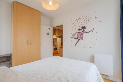 una camera da letto con un letto e un quadro sulla parete di Chez Maïté a Vals-les-Bains