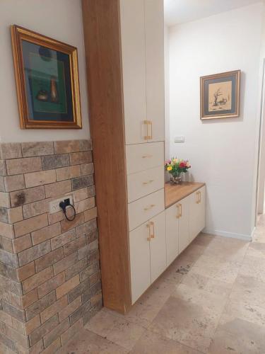 a room with a brick wall next to a dresser at בית בערבה in Mitzpe Ramon
