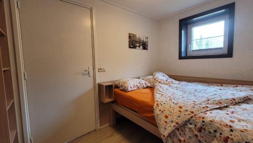 a small bedroom with a bed and a window at Le Vieux Sart 1 in Stavelot