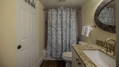 a bathroom with a toilet and a shower curtain at 2405 Ocean Pointe Suites in Tavernier