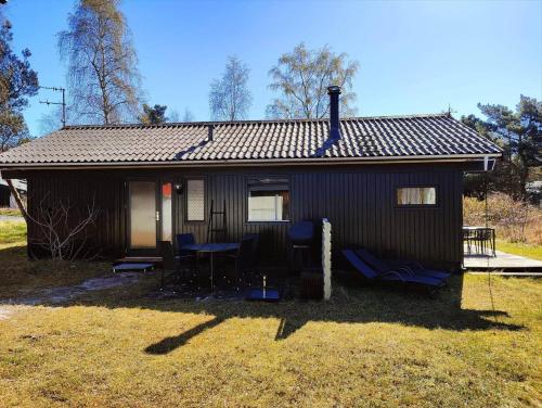 a small house with blue chairs in front of it at 1617-Aakirkeby-Poserekrogen-27 in Vester Sømarken