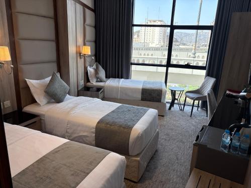 a hotel room with two beds and a large window at سقيا طيبة Suqya Taiba in Medina