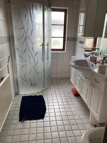 a bathroom with a shower and a blue towel on the floor at Sandbybäcksvägen 1 in Borrby