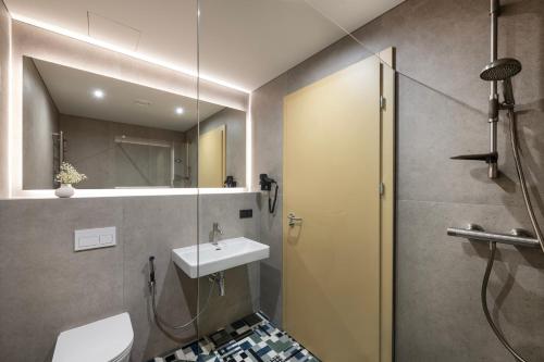 a bathroom with a sink and a shower with a mirror at Snow Hotel Druskininkai in Druskininkai