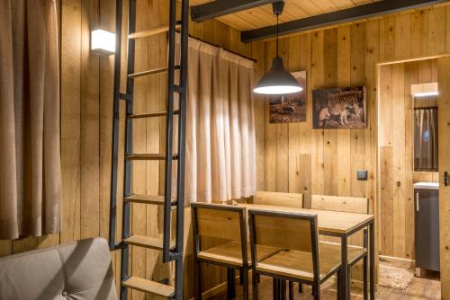a wooden room with a table and a ladder at Bungalows Verneda Mountain Resort in Arrós