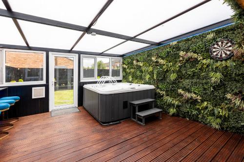 a room with a bath tub and a green wall at Riverside Villas in Manchester