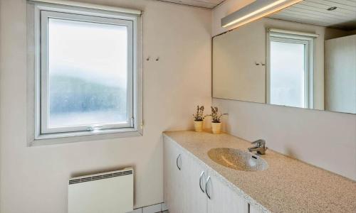 a bathroom with a sink and a mirror and a window at VE265-Vejers-Strand-Nordvej-98-A in Vejers Strand
