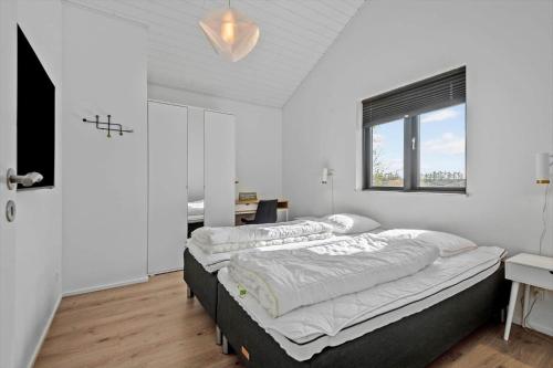 a bedroom with two beds and a desk and a window at HS018-Henne-Hennebysvej-8 in Henne Strand