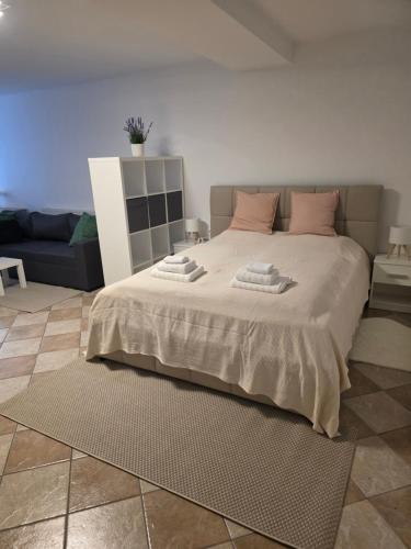 a bedroom with a large bed with pink pillows at Cosy Studio CatHouse in Radovljica