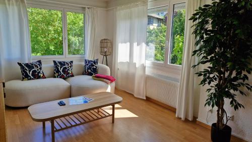 a living room with a couch and a table at Swiss Lakeside Apartments in Spiez
