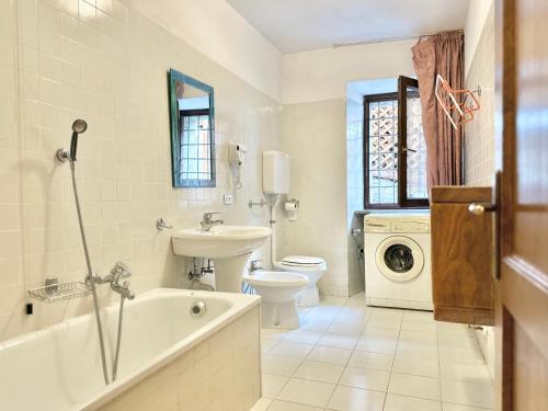 a bathroom with a tub sink and a toilet at Chalet Rustico Bertolini per Gruppi! in Vermiglio