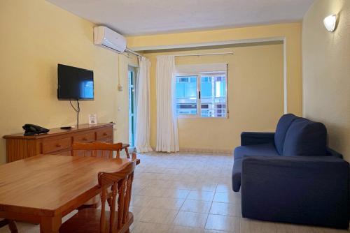 a living room with a blue couch and a table at Climia 2Sleep Apartments in Benidorm