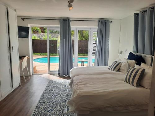 a bedroom with two beds and a swimming pool at Berg and Dal in Paarl