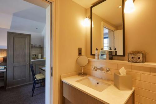 a bathroom with a sink and a mirror at The Swan, Streatley, Berkshire in Streatley