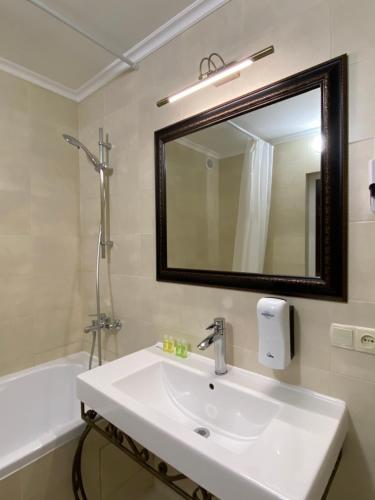 a bathroom with a sink and a mirror and a tub at Житловий будинок in Bilhorod-Dnistrovskyi