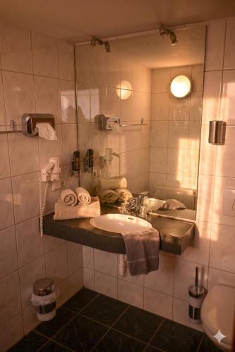 a bathroom with a sink and a mirror at Malerwinkel Hotel in Wertheim