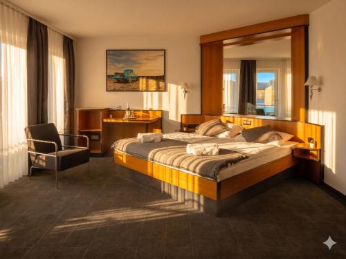 a hotel room with a large bed and a chair at Malerwinkel Hotel in Wertheim