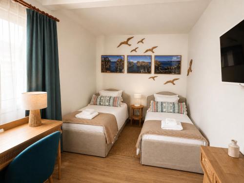 two beds in a room with birds flying overhead at Pico Island Villas 38 - Private Atlantic Retreat in Santo António