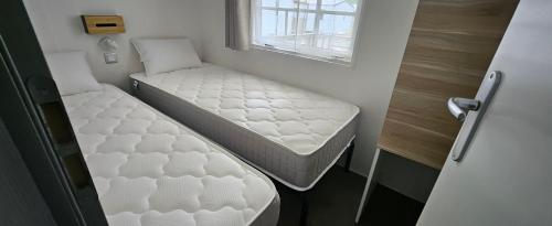 two beds in a small room with a window at A 15 minutes de l'océan, Mimizan plage in Aureilhan