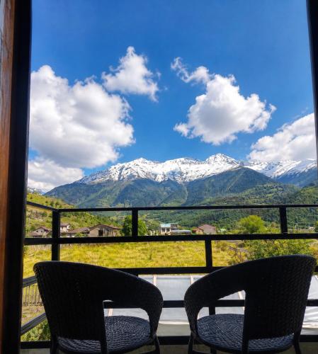 two chairs on a balcony with a view of mountains at Ninama in Mestia