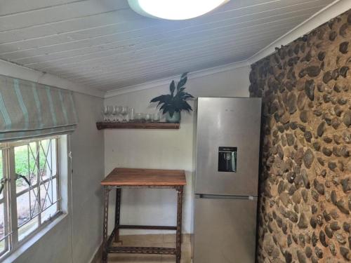 a kitchen with a refrigerator and a table next to a window at River Glen Farm in Winterton
