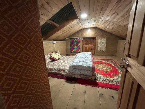 an attic bedroom with a bed in a room at The magic meadows in Kulu