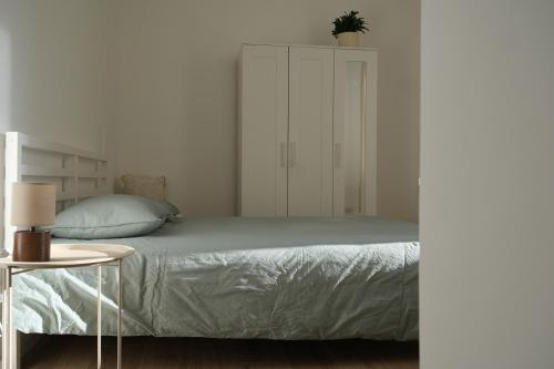 a white bedroom with a bed and a cabinet at Amati Bed & Breakfast in Lecce