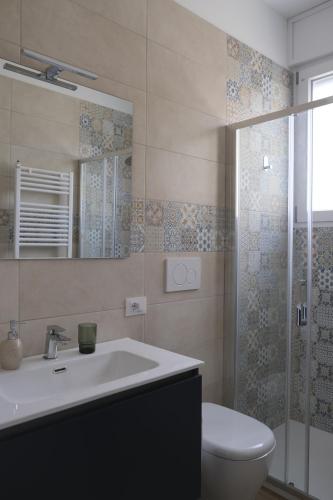 a bathroom with a sink and a toilet and a mirror at Amati Bed & Breakfast in Lecce