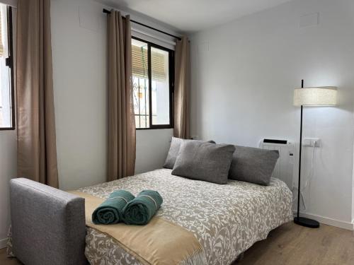 a bedroom with a bed with two pillows and a window at LaJoya Zuheros Suite in Zuheros