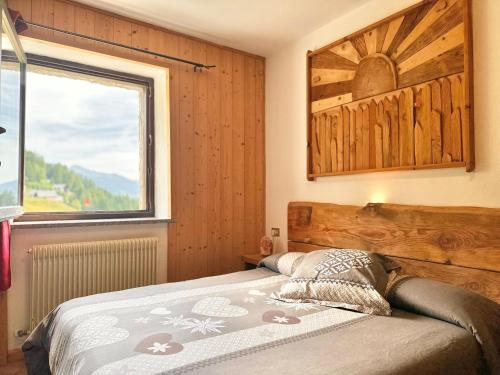 a bedroom with a bed with a large window at Chalet Rustico Bertolini per Gruppi! in Vermiglio