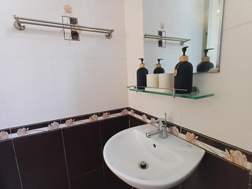 a bathroom with a white sink and a mirror at Green Hillside Villa Hue in Hue
