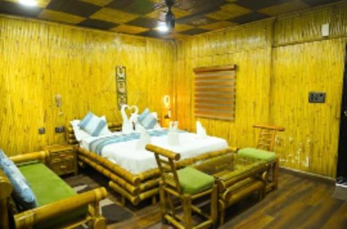a bedroom with a bed and chairs in a room at Hotel First Impression in Rāmnagar
