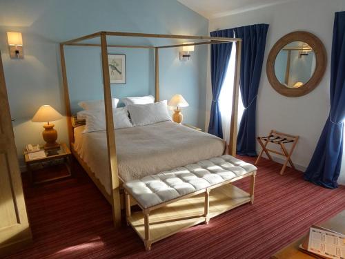 a bedroom with a canopy bed and a mirror at Les chambres du Domaine Rollan de By in Bégadan