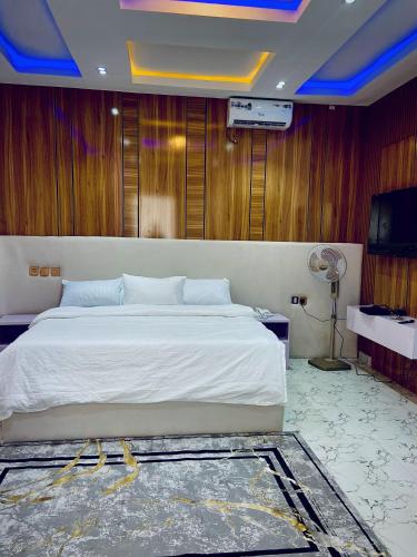 a bedroom with a large bed and a television at King Arthur Apartment in Akwa