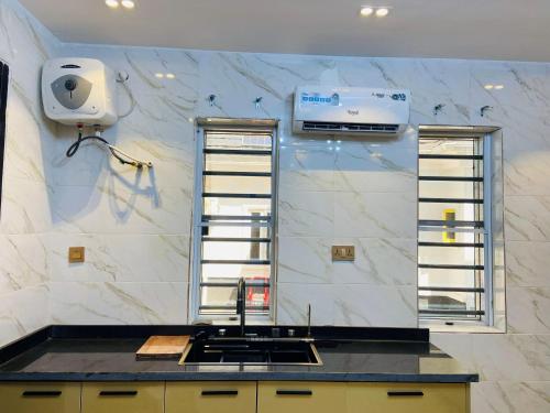a kitchen with white marble walls and a counter top at King Arthur Apartment in Akwa