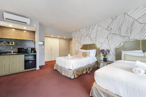 a hotel room with two beds and a kitchen at Alamo Hotel in Miami Beach