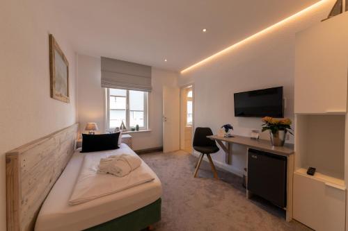 a bedroom with a bed and a desk with a computer at Marin Hotel Sylt GmbH in Westerland