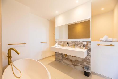 a bathroom with a white sink and a mirror at Villa Adeona in Zonza