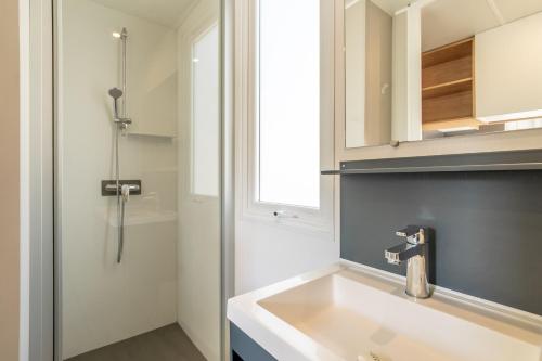 a bathroom with a white sink and a mirror at Camping Valras plage 5 étoiles in Vendres