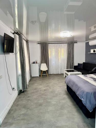 ein Schlafzimmer mit einem Bett und einer Couch in der Unterkunft La DeDe in Calafat