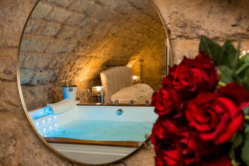 a mirror in a bathroom with a bath tub at Dimora Don Gabriele e Suite in Mola di Bari