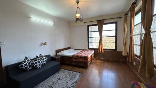 a room with a bed and a couch and a window at Lloyd's Vintage Home in Bhowāli