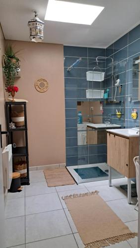 a bathroom with a sink and a shower with blue tiles at TURQUOISE in Linxe