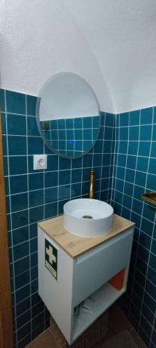 a blue tiled bathroom with a sink and a mirror at Casa da Capinha Rota - Moura in Moura