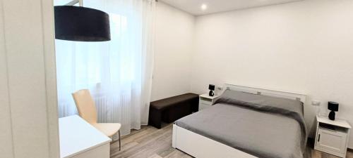 a bedroom with a bed and a desk and a chair at Chez Romeo in Ravenna